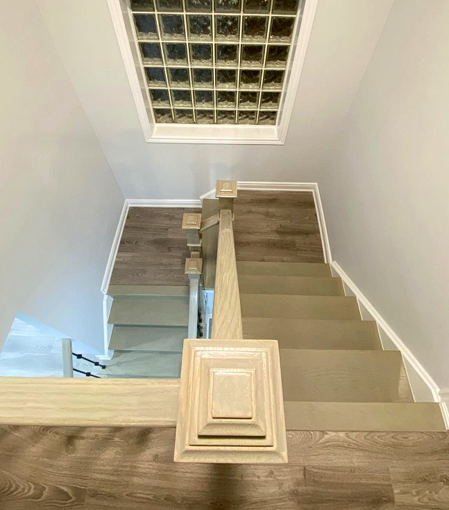 Glass-block skylight casting light down a hardwood stairwell